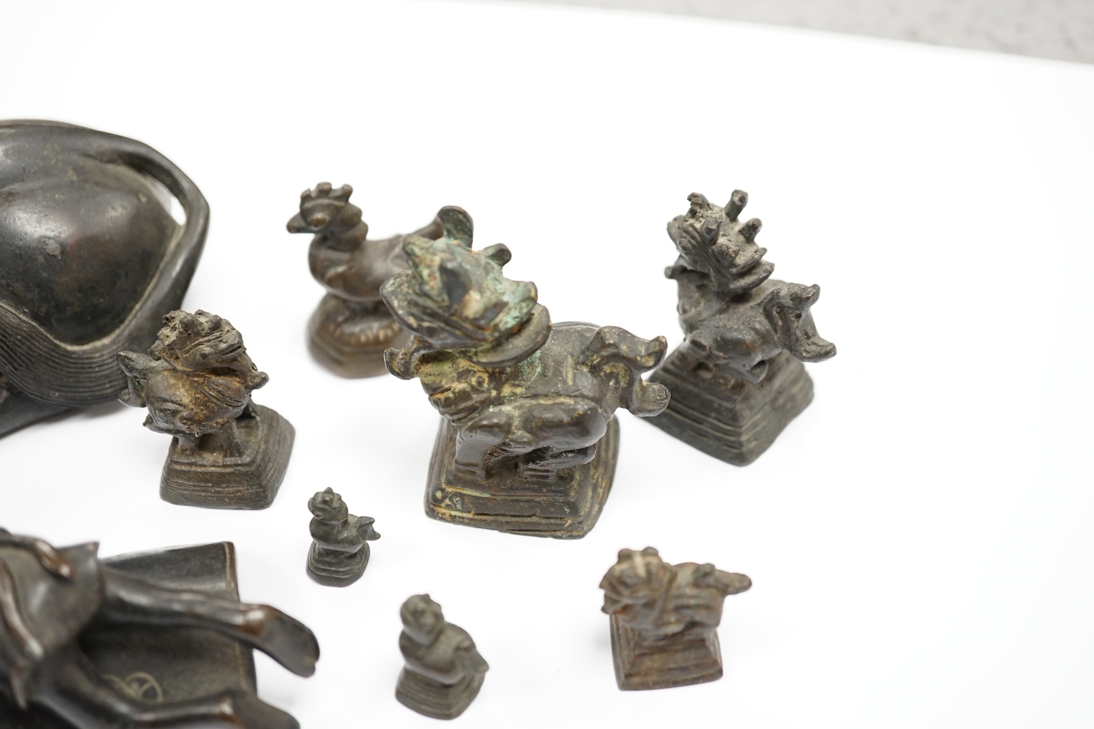 A Chinese bronze ‘water buffalo’ box and cover, Qing dynasty, and a set of Burmese opium weights, largest 18cm long